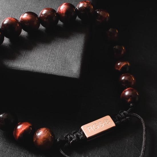 Red Tiger Eye Bead Bracelet - Our Red Tiger Eye Bead Bracelet Features Natural Stones, Waxed Cord and Brushed Rose Gold Steel Hardware. A Beautiful Addition to any Collection.